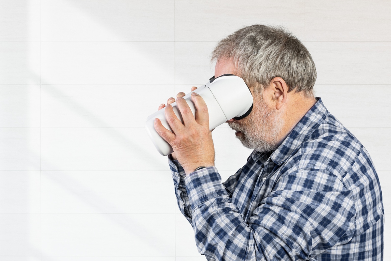 Ein älterer Mann hält sich das Gerät von Visotec vor die Augen